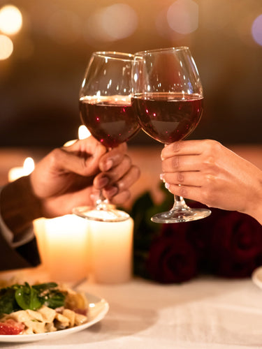 Rotwein im Glas mit Flasche auf Holztisch – stilvoller Weingenuss in gemütlichem Ambiente